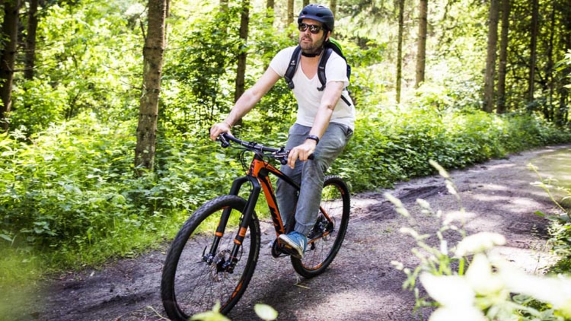 Foto: Oberösterreich Tourismus/Einzenberger: Mountainbiken im Mühlviertel Das Bild zeigt den Fotograf und Filmemacher Ingo Pertramer, der mit dem Mountainbike auf einem Waldweg fährt.